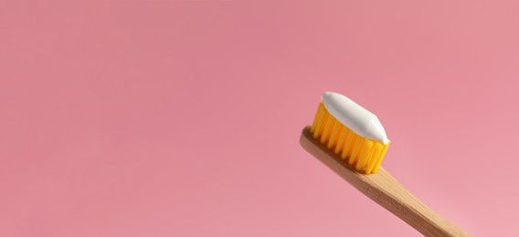 Image of Brush with toothpaste on pink background, space for text. Banner design