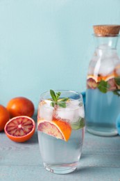 Photo of Delicious refreshing drink with sicilian orange and mint on grey wooden table