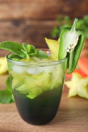 Spicy cocktail with jalapeno, carambola and mint on wooden table, closeup