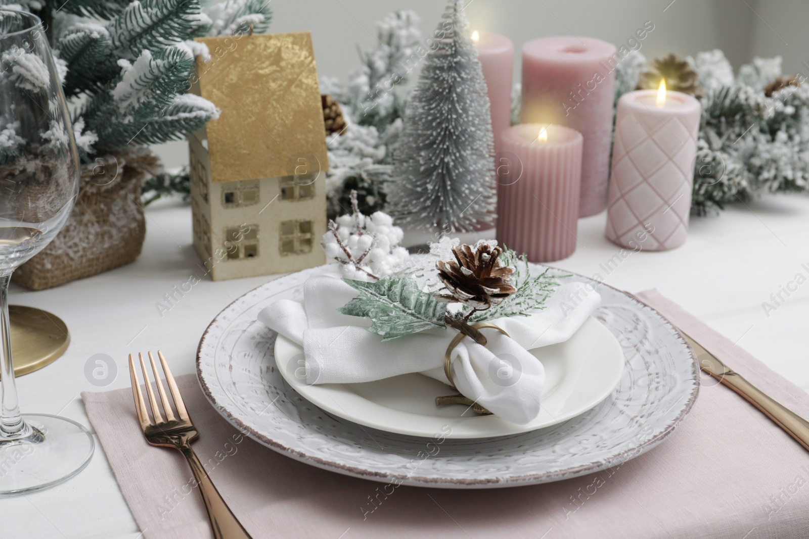 Photo of Festive place setting with beautiful dishware, cutlery and cone for Christmas dinner on white wooden table