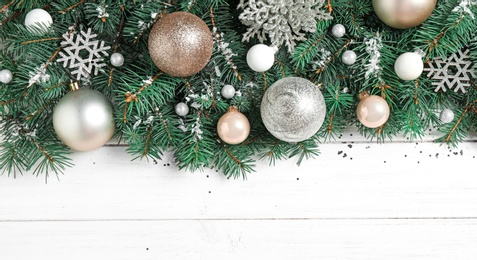 Fir tree branches with Christmas decoration on white wooden background, flat lay. Space for text