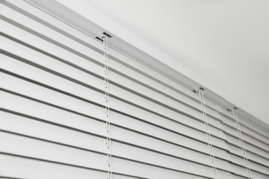 Photo of Closeup view of horizontal blinds on window indoors