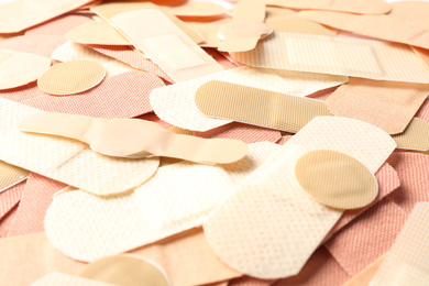 Photo of Different medical sticking plasters as background, closeup. First aid item