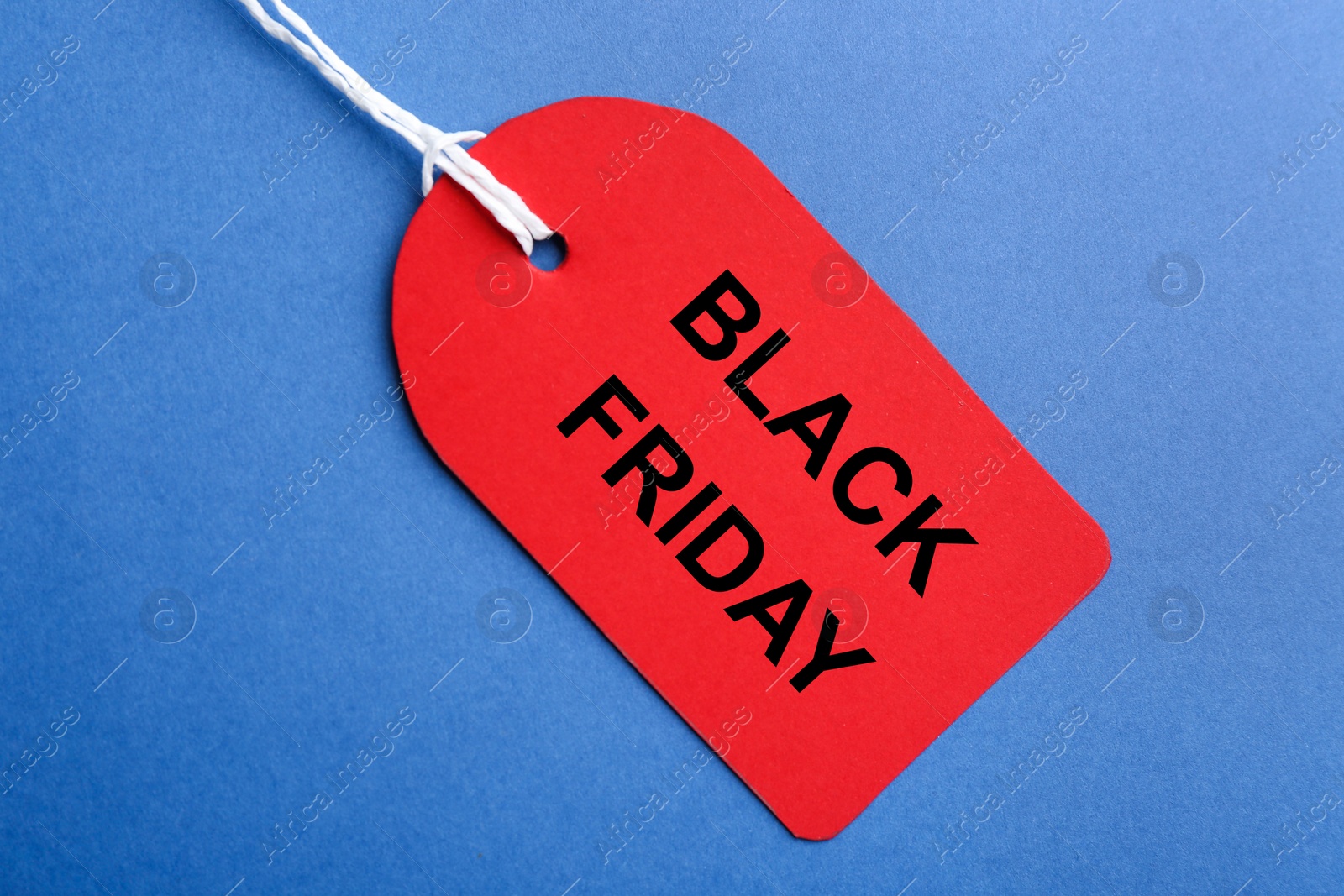 Photo of Red blank tag on blue background, top view. Black Friday concept