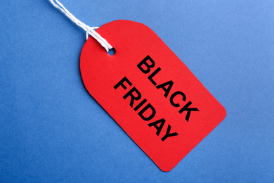 Photo of Red blank tag on blue background, top view. Black Friday concept