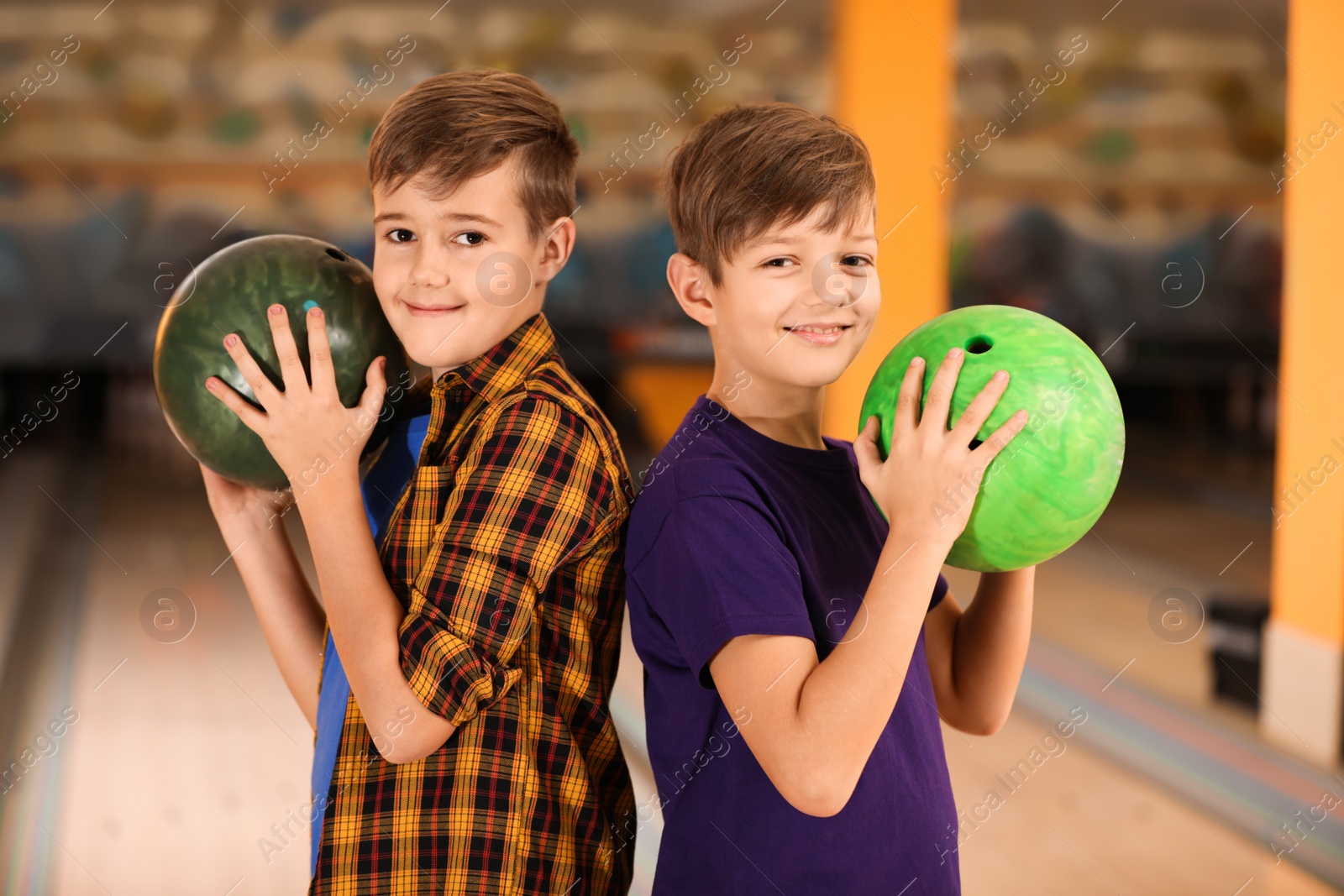 Photo of Happy boys with balls in bowling club