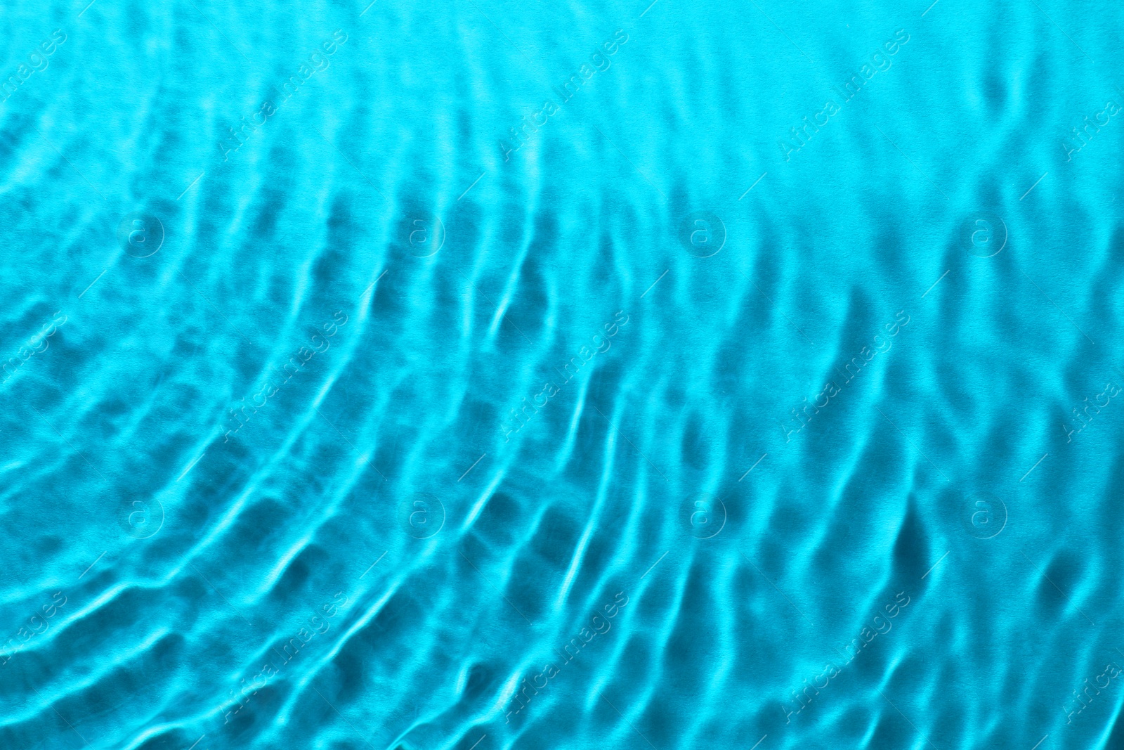 Image of Rippled surface of clear water on light blue background, top view