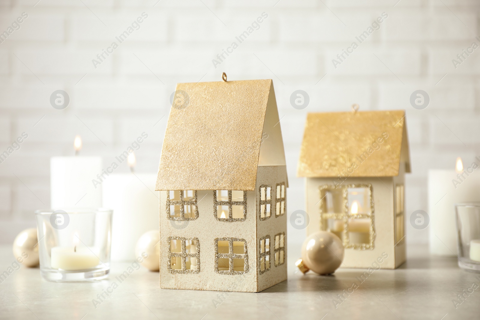 Photo of Composition with house shaped candle holders on light table. Christmas decoration