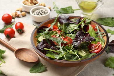 Photo of Tasty fresh vegetarian salad and ingredients on grey table, closeup