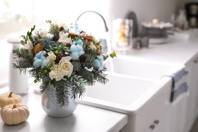 Photo of Beautiful winter bouquet on table in kitchen