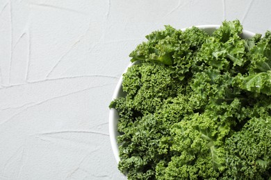 Fresh kale leaves on white table, top view. Space for text