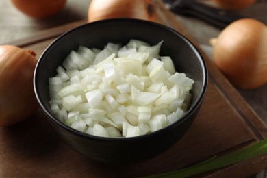 Photo of Whole and cut onion on wooden table, closeup