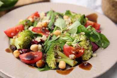 Photo of Tasty salad with balsamic vinegar in plate, closeup