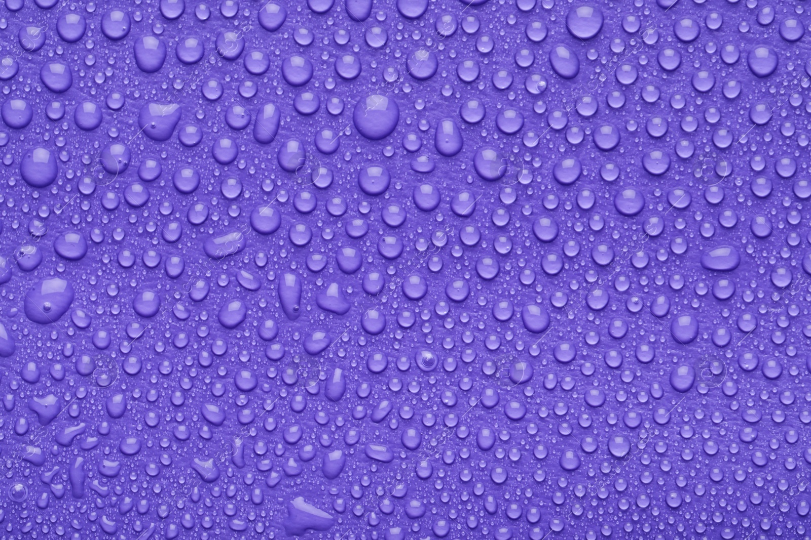 Photo of Water drops on lilac background, top view