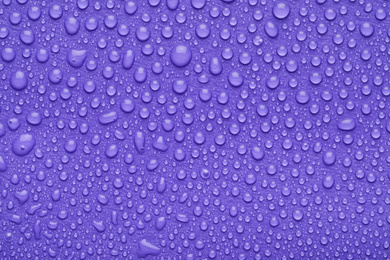 Photo of Water drops on lilac background, top view