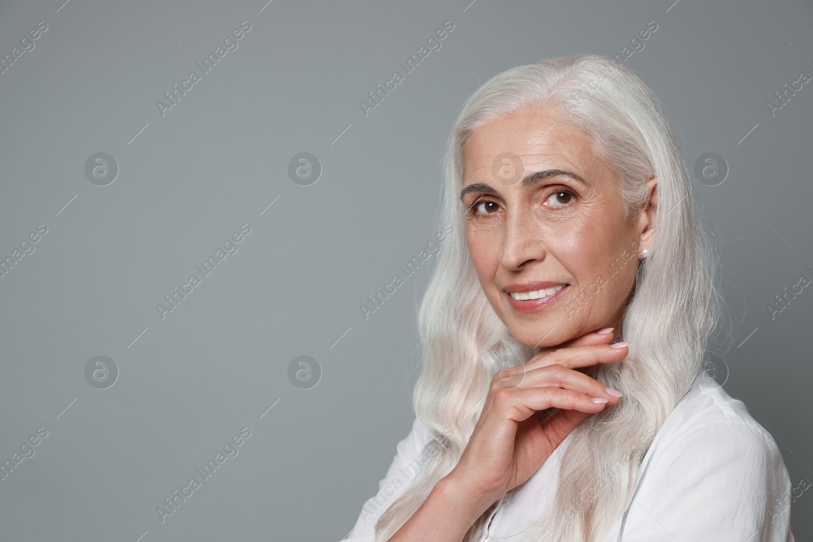 Photo of Portrait of beautiful mature woman on grey background, space for text