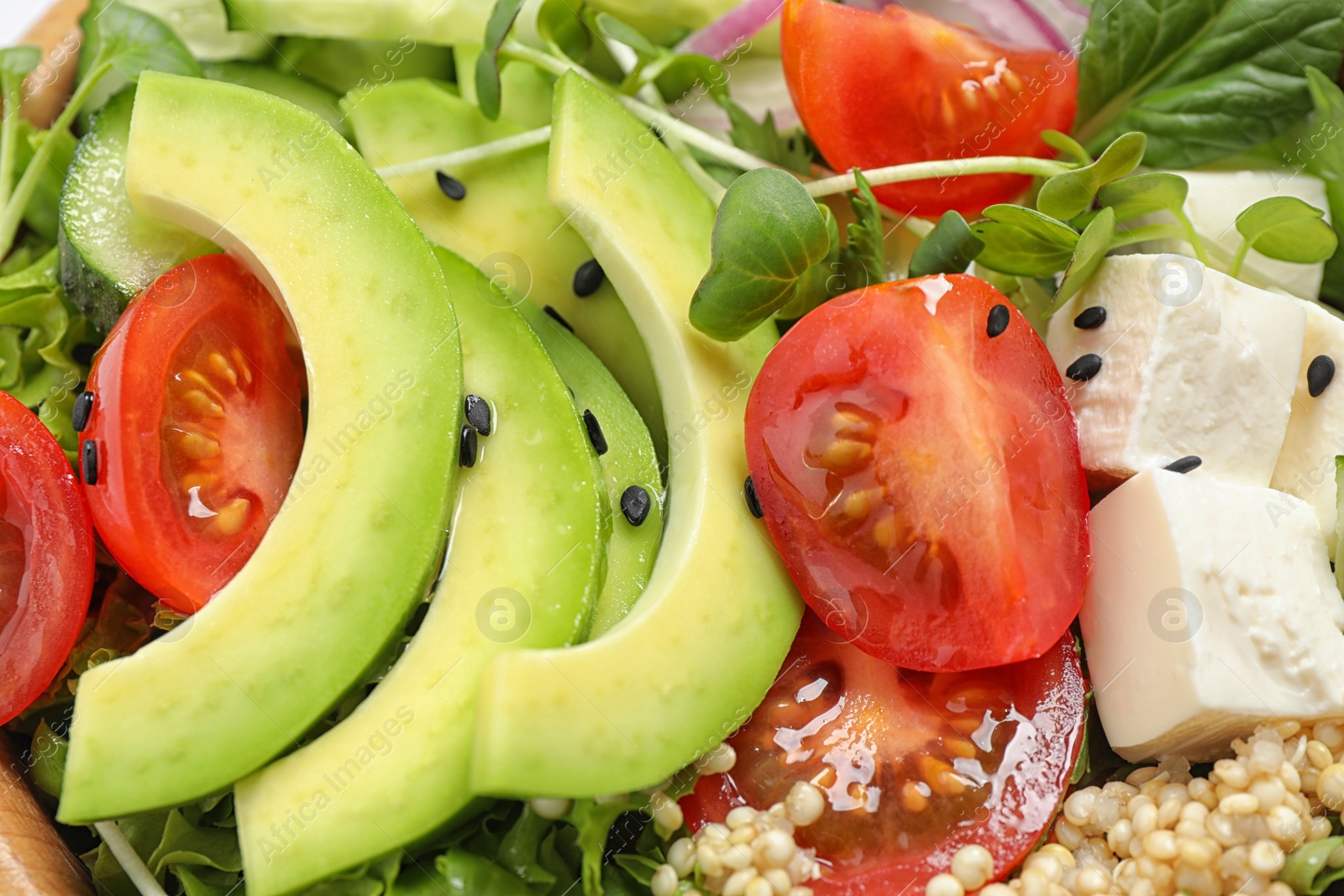 Photo of Delicious avocado salad with quinoa as background, closeup