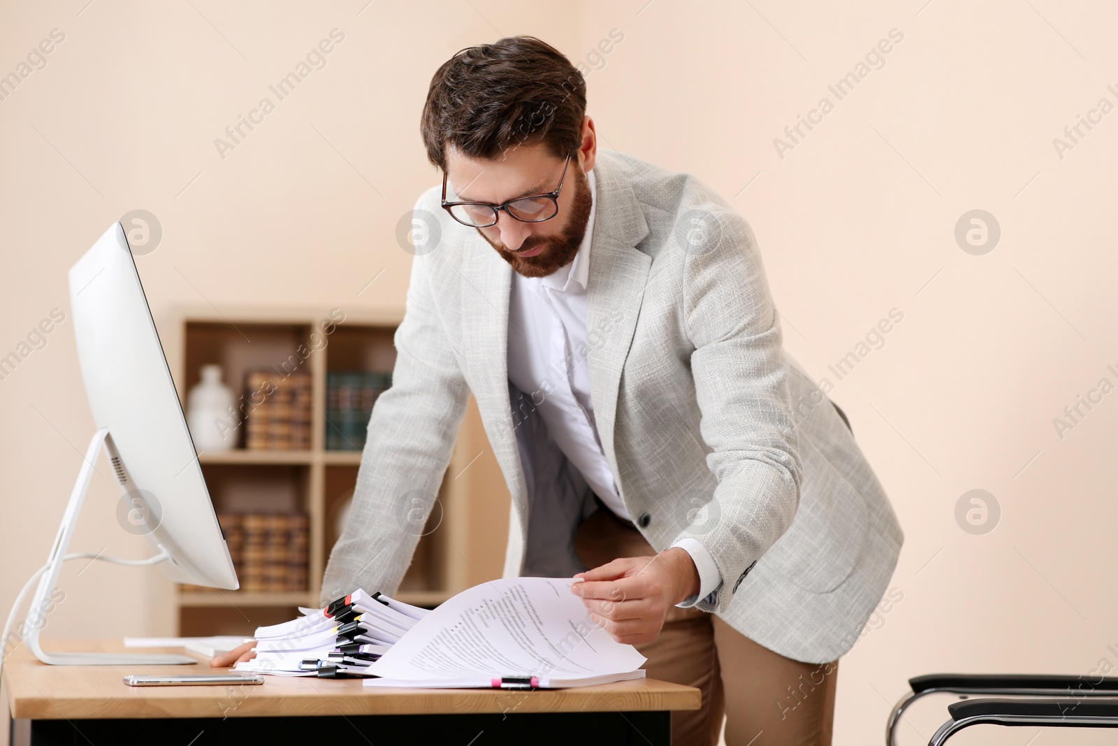 Photo of Businessman working with documents at wooden table in office