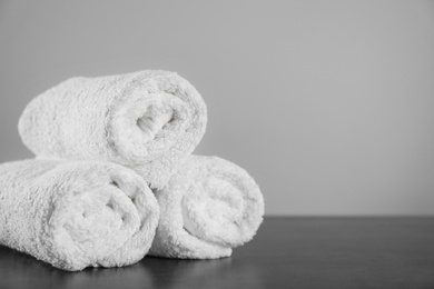 Photo of Clean rolled towels on dark grey table. Space for text