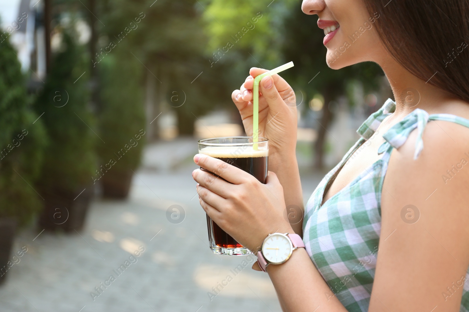 Photo of Young woman with cold kvass outdoors, closeup. Traditional Russian summer drink