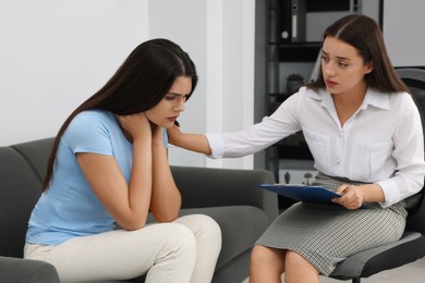 Professional psychologist working with young woman in office