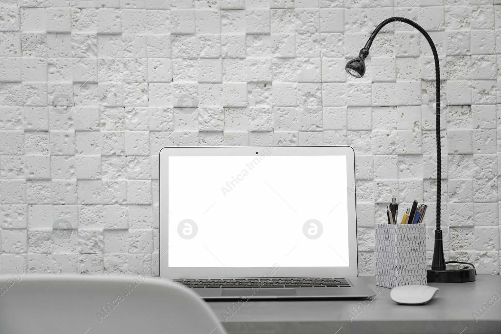 Photo of Laptop on desk against light wall in home office. Comfortable workplace