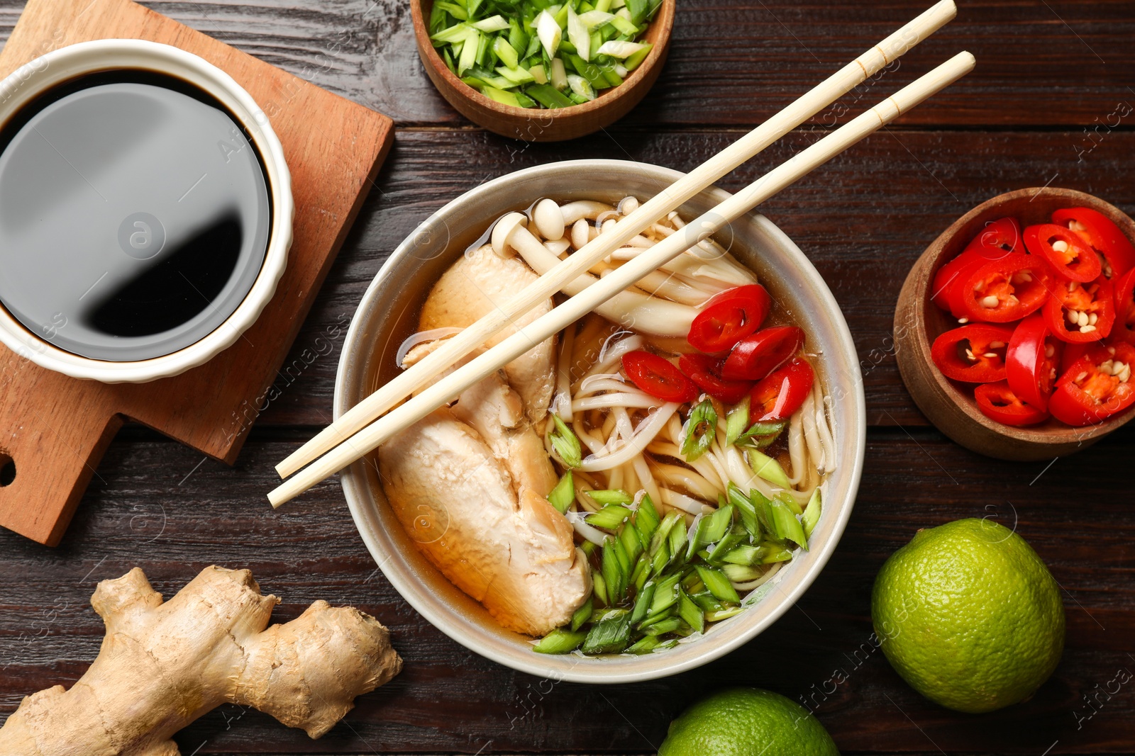 Photo of Delicious ramen with meat and ingredients on wooden table, flat lay. Noodle soup