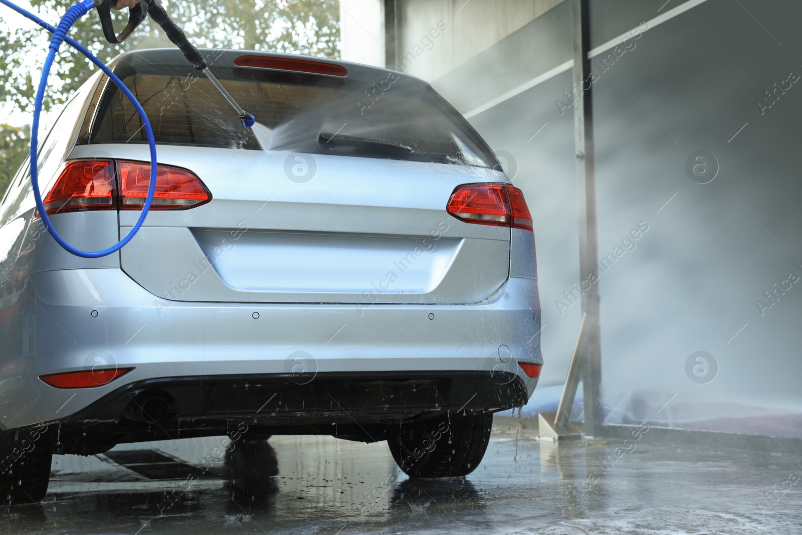 Photo of Washing auto with high pressure water jet at outdoor car wash, low angle view