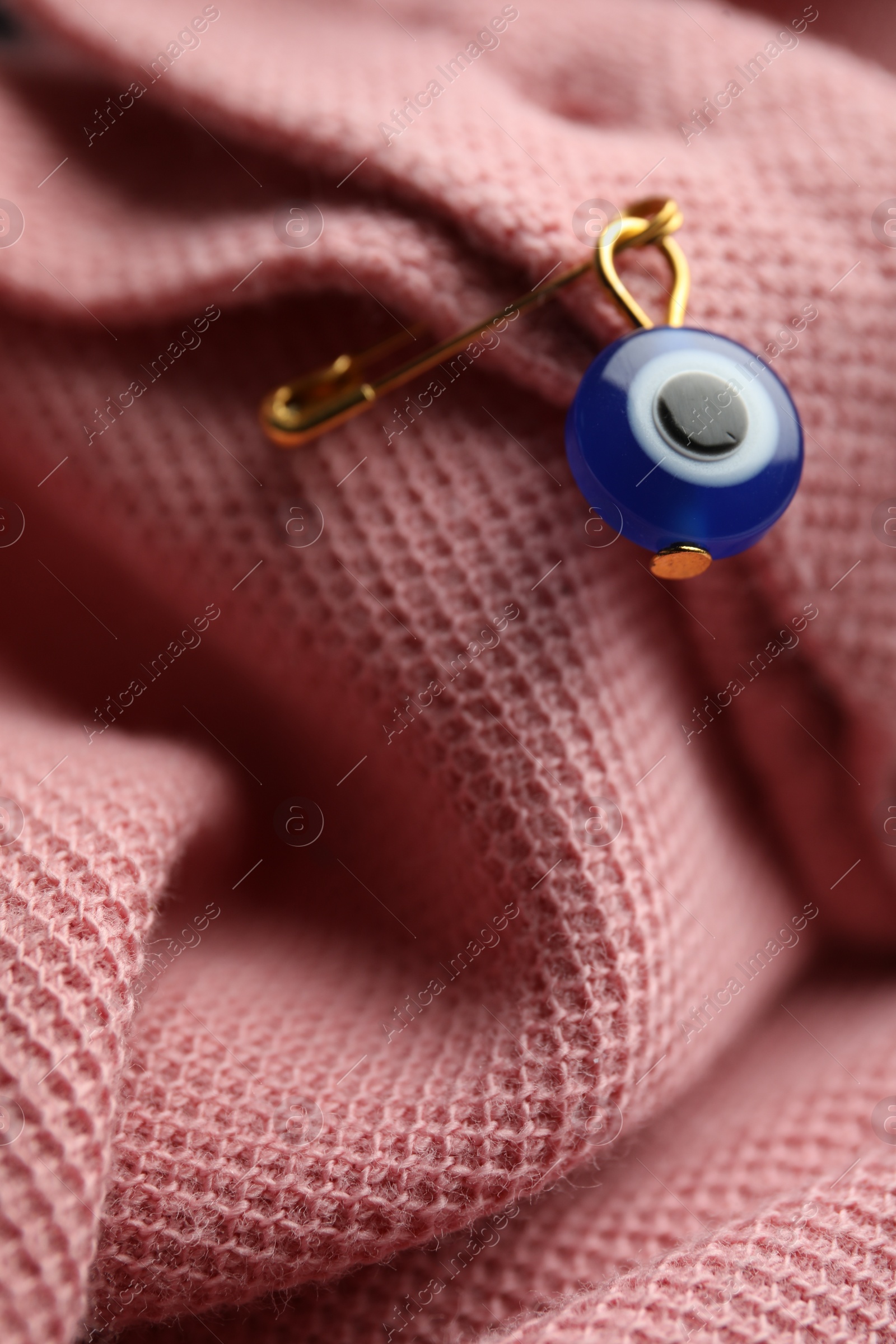 Photo of Evil eye safety pin on clothing, closeup