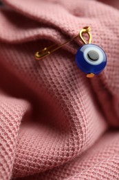 Photo of Evil eye safety pin on clothing, closeup