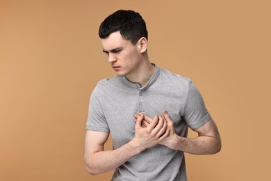 Photo of Man suffering from heart hurt on beige background