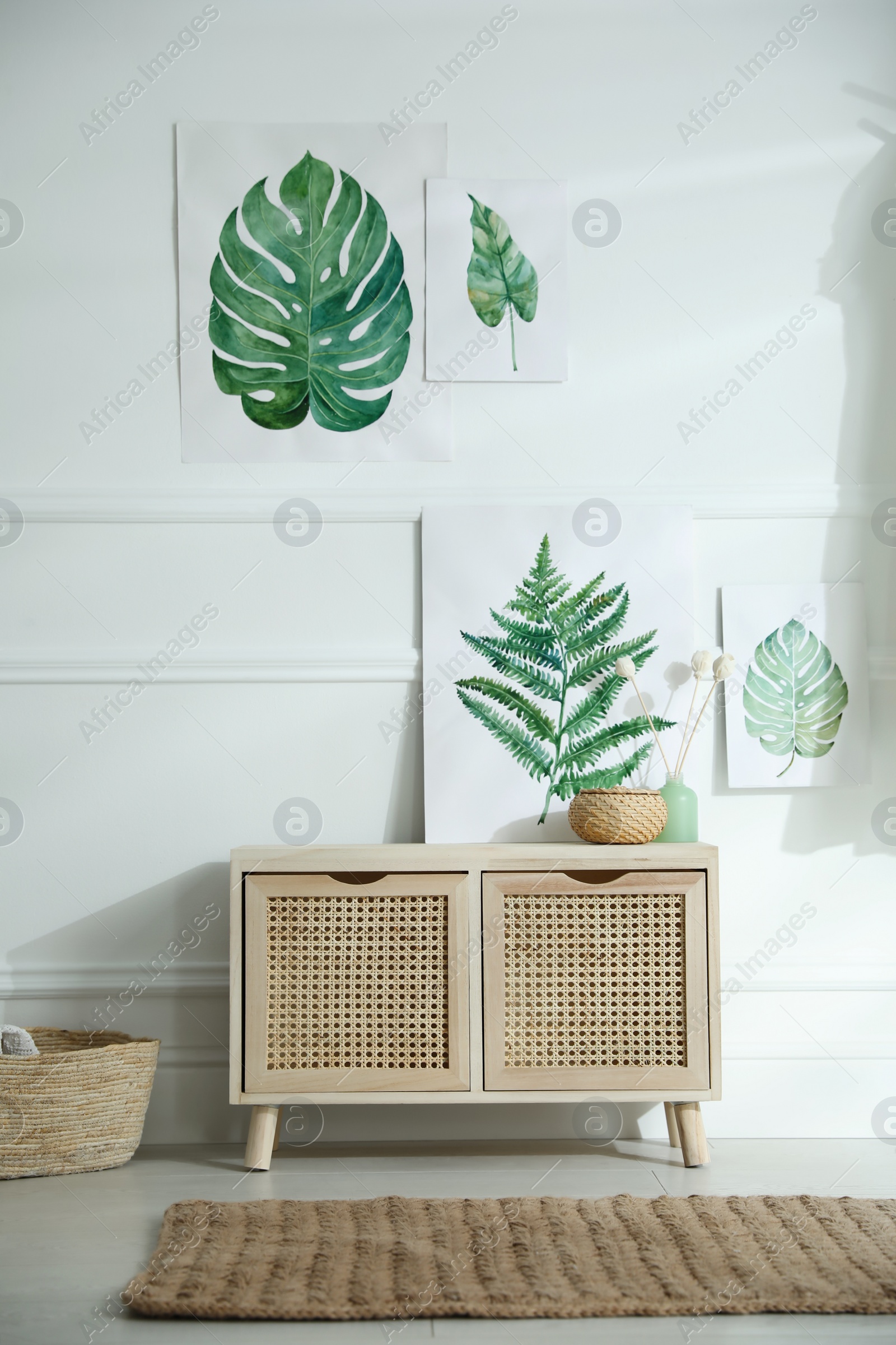 Photo of Wooden commode near white wall in room. Interior design