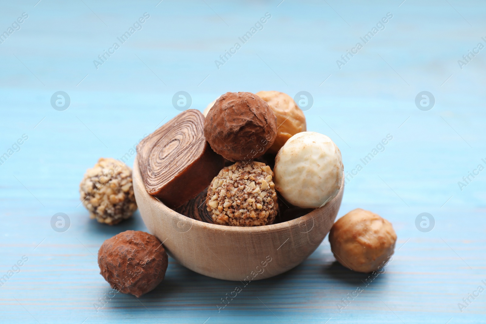 Photo of Tasty chocolate candies on light blue wooden table