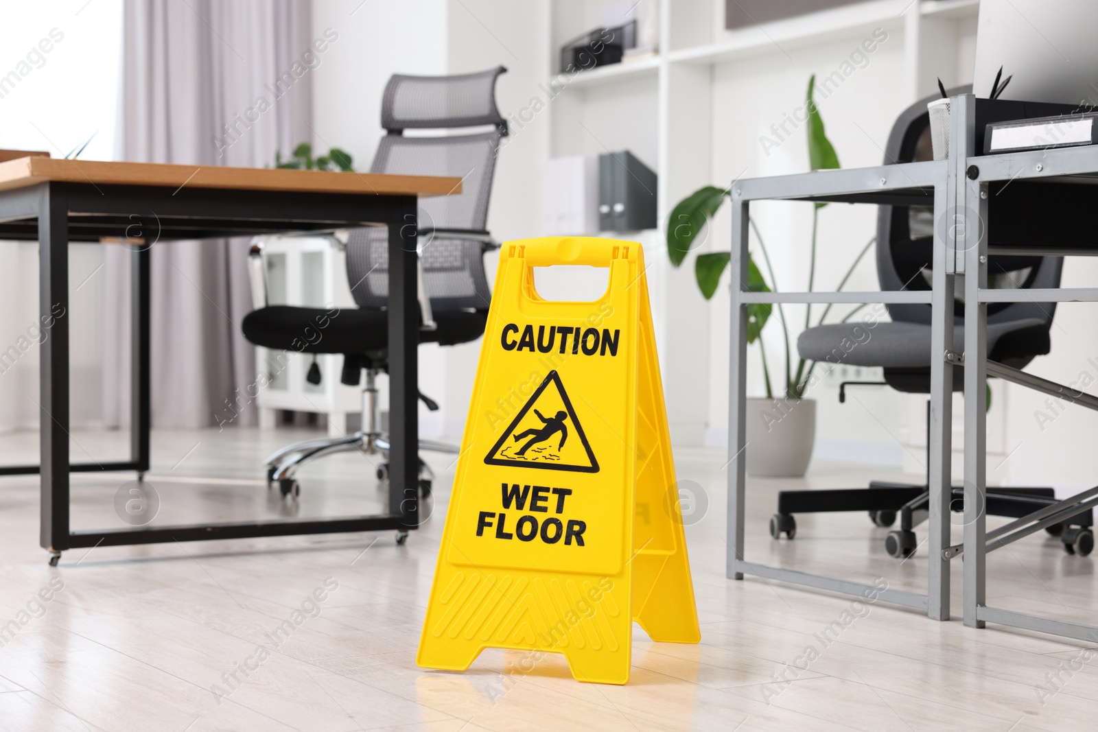 Photo of Cleaning service. Wet floor sign in office