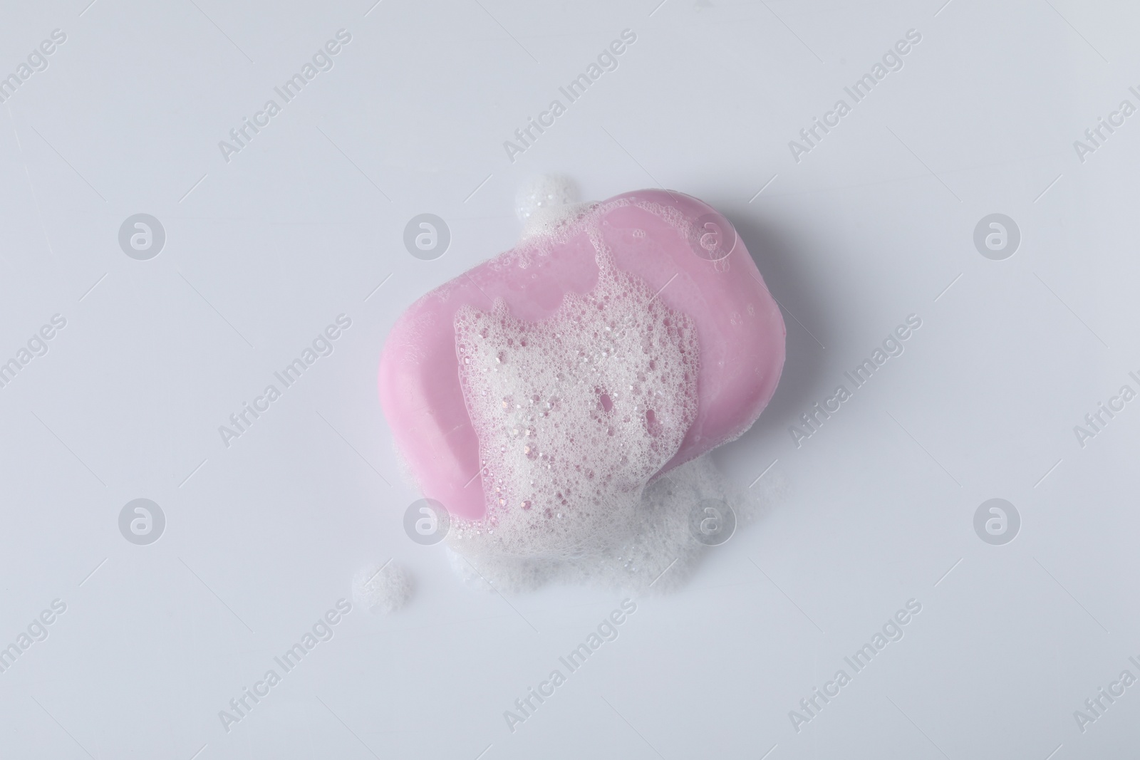 Photo of Soap with fluffy foam on white background, top view