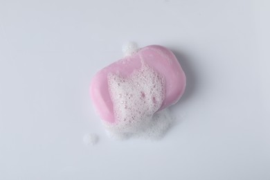Photo of Soap with fluffy foam on white background, top view