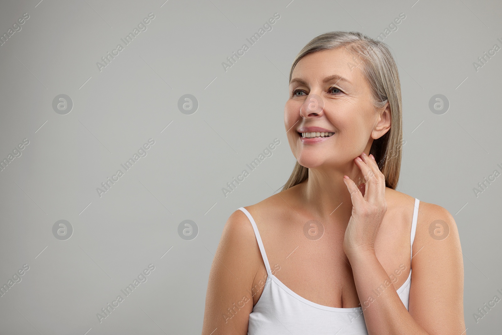 Photo of Beautiful woman touching her neck on grey background, space for text