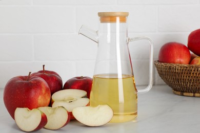 Photo of Natural apple vinegar and fresh fruits on white marble table