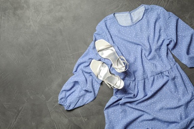 Photo of Stylish light blue dress and shoes on grey stone background, flat lay. Space for text