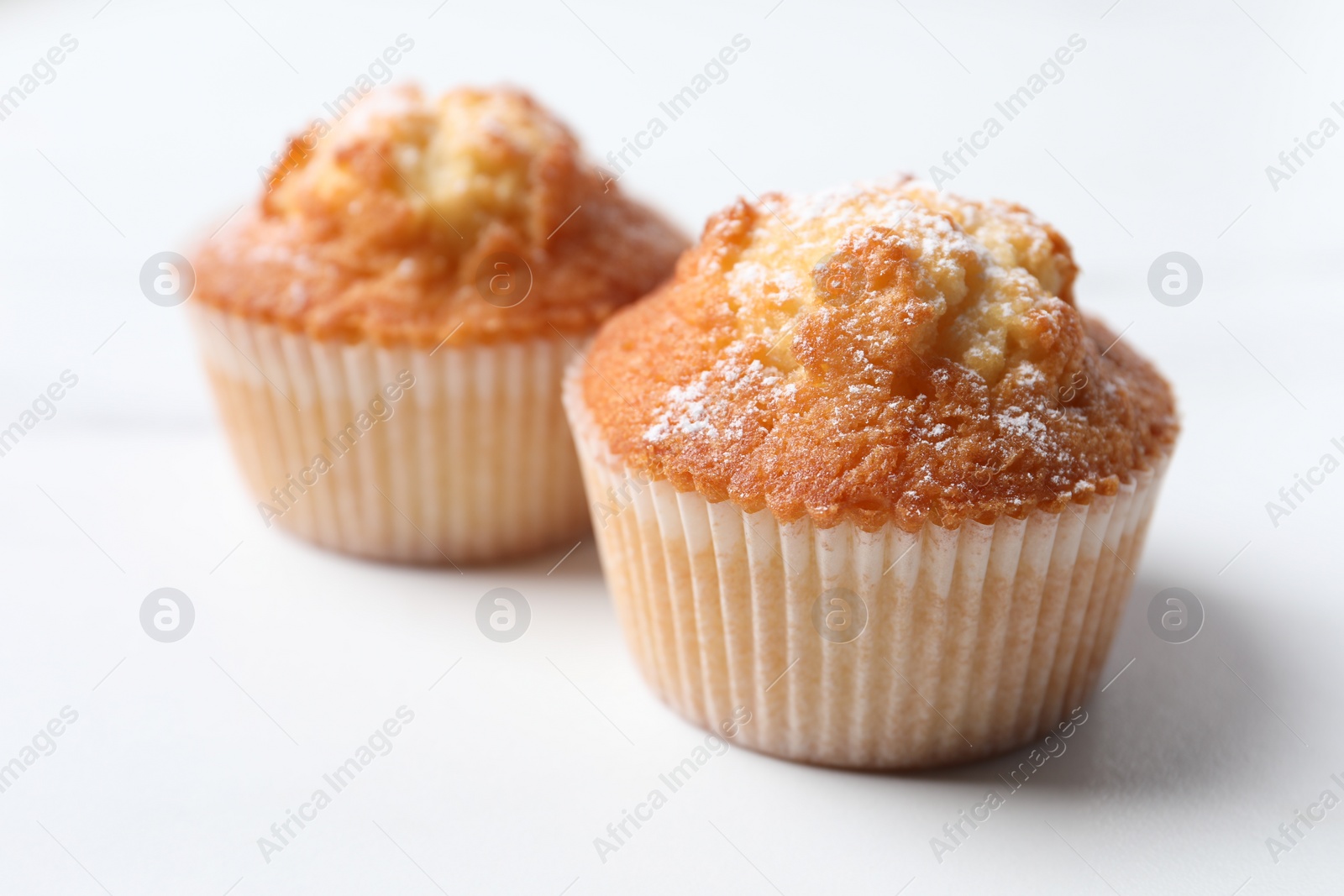 Photo of Delicious sweet muffins on white table, closeup