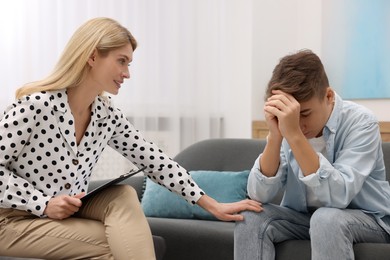 Psychologist working with teenage boy in office