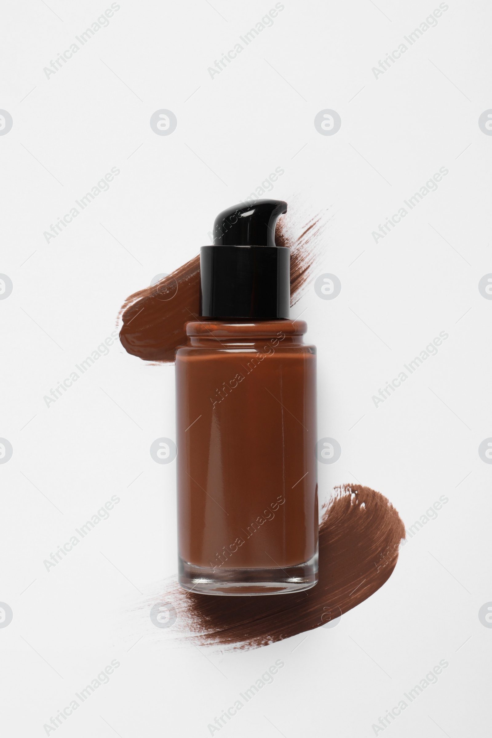 Photo of Liquid foundation and swatches on white background, top view