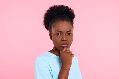 Photo of Portrait of concentrated young woman on pink background