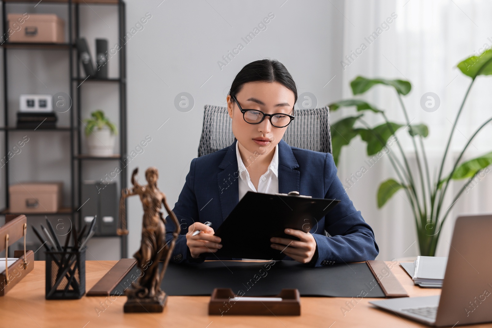 Photo of Notary reading document at table in office