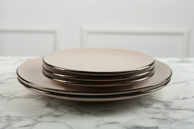 Beautiful ceramic plates on white marble table indoors, closeup