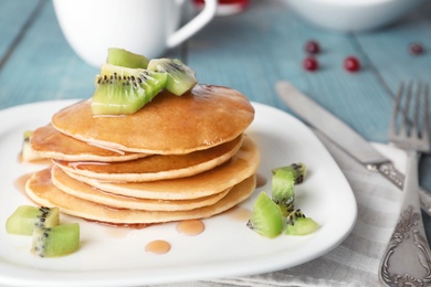 Photo of Plate with delicious pancakes on table