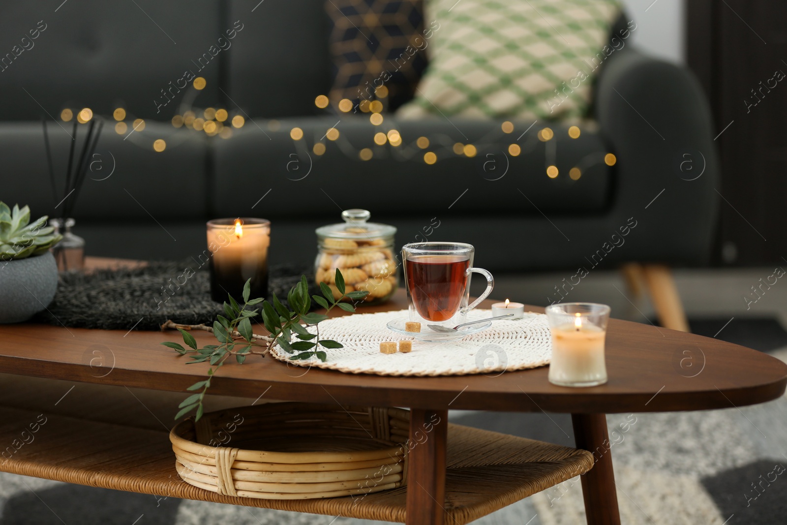 Photo of Tea, cookies and decorative elements on wooden table in living room