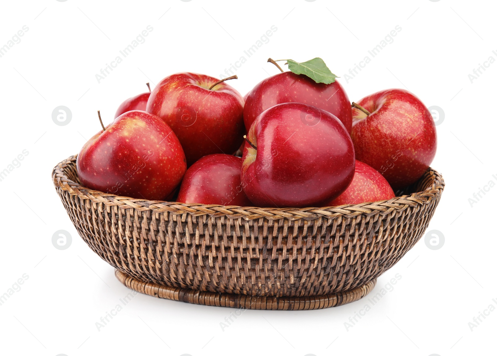 Photo of Wicker bowl of ripe juicy red apples with leaf on white background