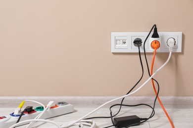 Photo of Extension cord with power plugs in sockets indoors, space for text
