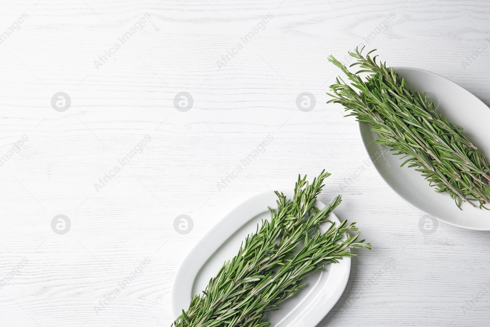 Photo of Flat lay composition with rosemary and space for text on light background. Aromatic herbs